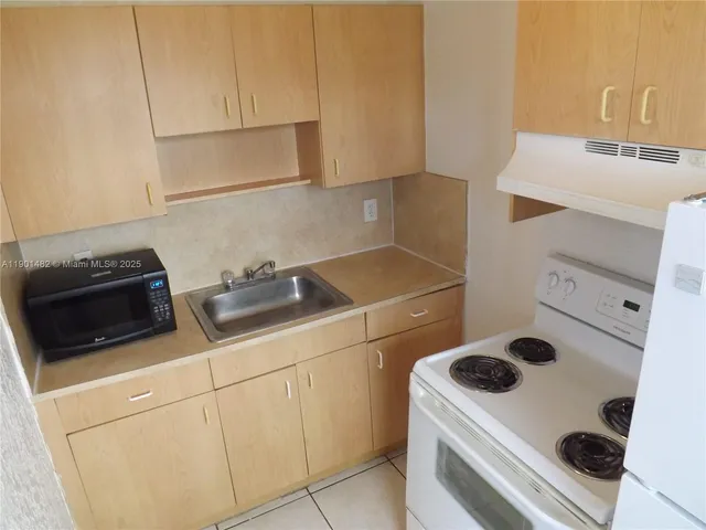 a kitchen with a sink and a stove top oven