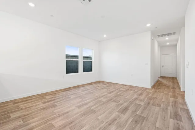 a view of an empty room with wooden floor