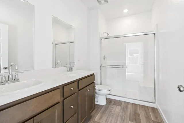 a bathroom with a granite countertop sink toilet a mirror and shower