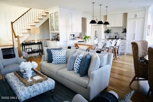 a living room with furniture kitchen view and a chandelier