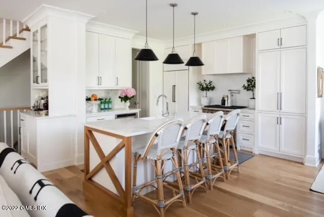 a kitchen with stainless steel appliances kitchen island granite countertop a table chairs and a refrigerator