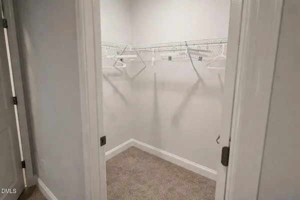 a spacious bedroom with a bed and a chandelier