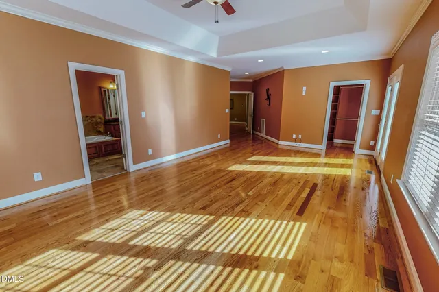 a view of a livingroom with wooden floor and a chandelier