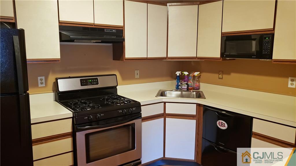 a kitchen with stainless steel appliances a stove a sink and a microwave