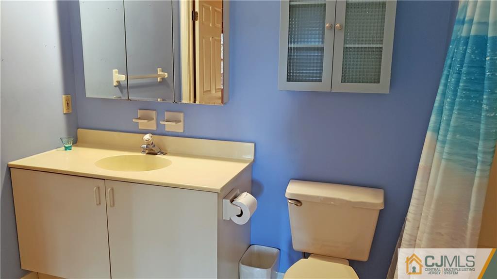 710 Meadow Court, Unit 710 Helmetta, NJ 08828 - Photo 3 of 11 a bathroom with a toilet sink and mirror