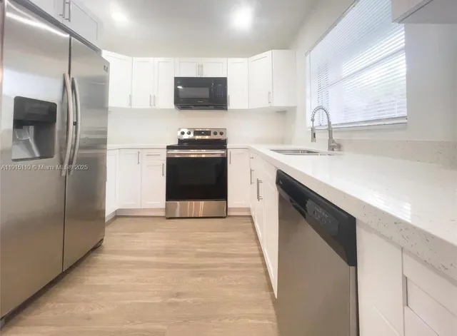 a kitchen with stainless steel appliances a refrigerator sink and microwave