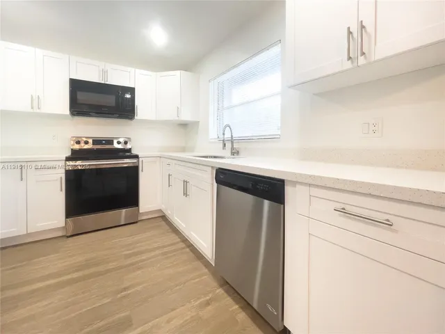 a kitchen with stainless steel appliances granite countertop a sink and a stove