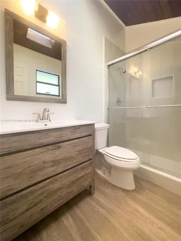 an empty room with a chandelier fan and windows