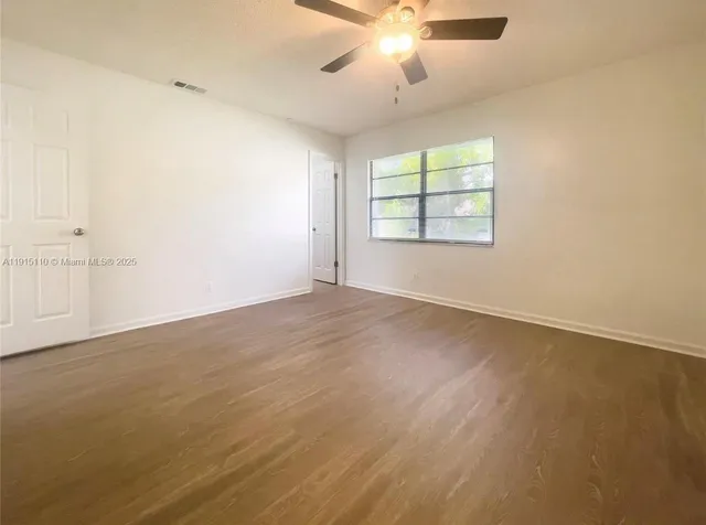 a view of empty room with wooden floor