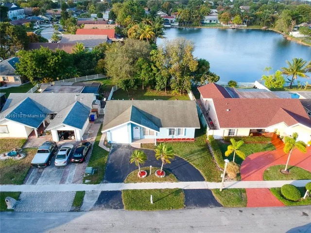 an aerial view of residential houses with outdoor space and lake view