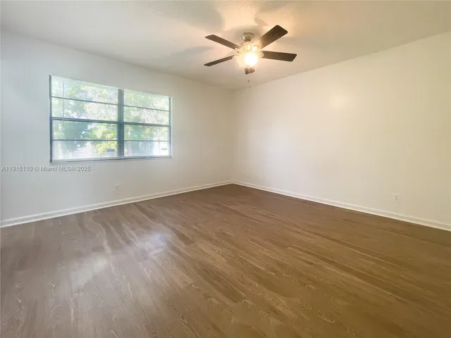 an empty room with a window and a fan
