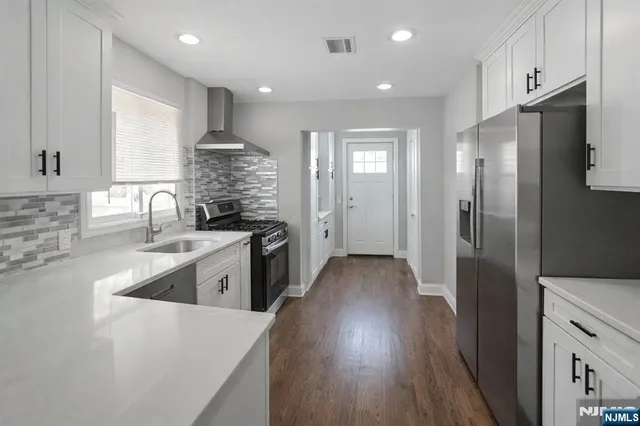 a kitchen with stainless steel appliances granite countertop a refrigerator stove and sink