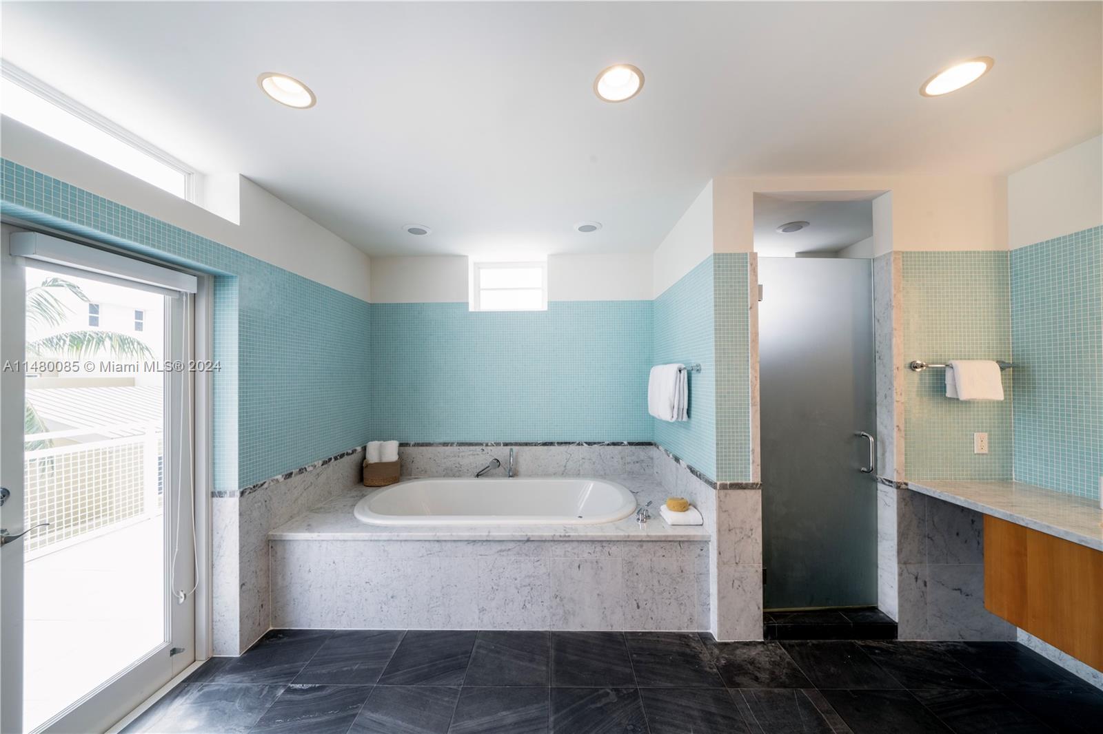 6010 Aqua Path Miami Beach, FL 33141 - Photo 42 of 65 a bathroom with a tub and shower