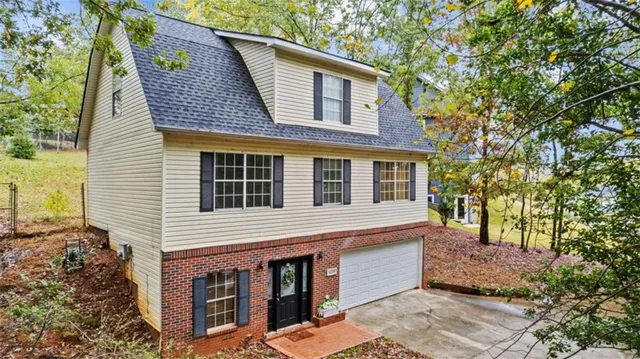 a front view of a house with a tree