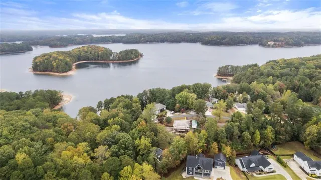 an aerial view of a house with yard and lake view