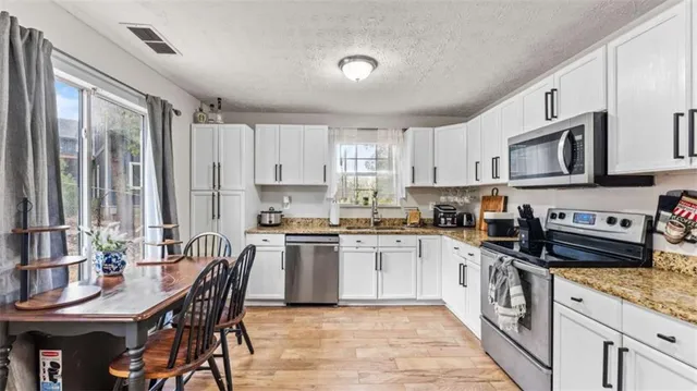 a kitchen with a stove a sink a microwave and cabinets