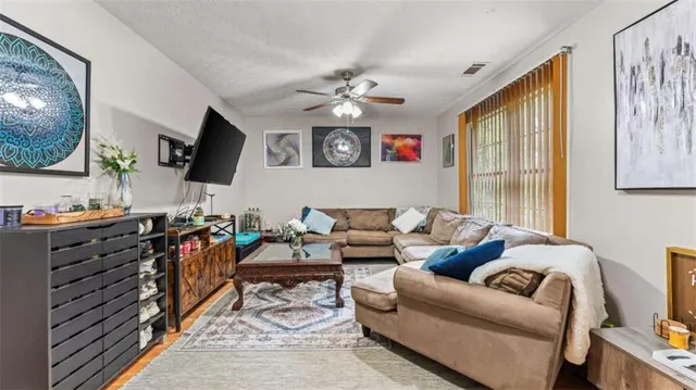 a living room with furniture a flat screen tv and a window