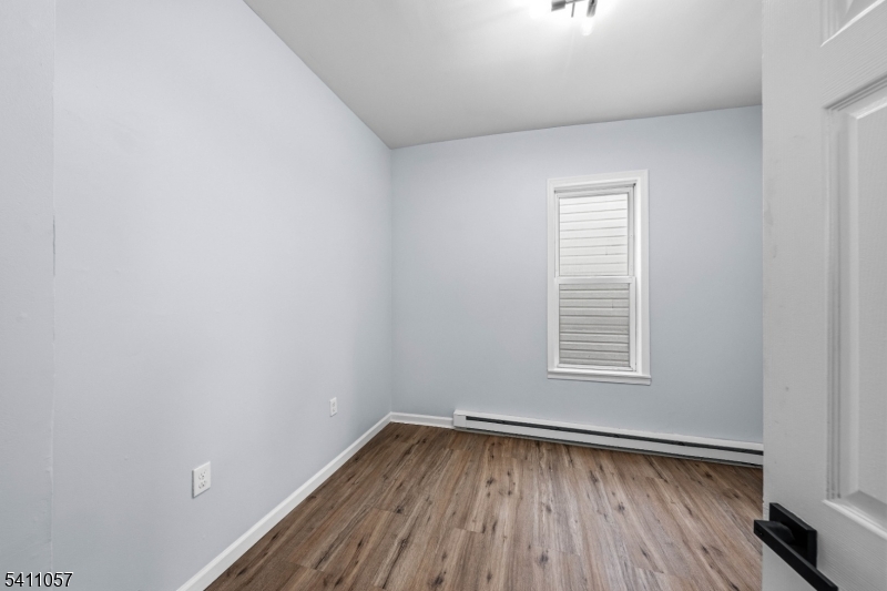 629 Magnolia Avenue Elizabeth Port, NJ 07206 - Photo 22 of 24 a view of an empty room with wooden floor and a window