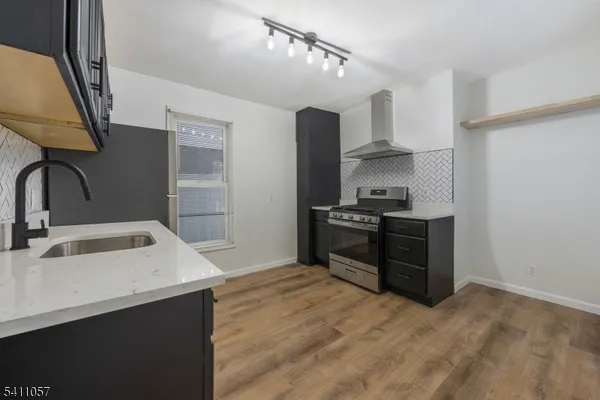 a kitchen with granite countertop a sink stove and refrigerator