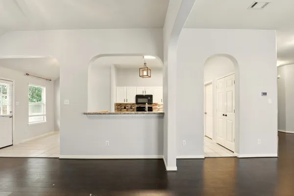 a view of a living room with wooden floor and a window