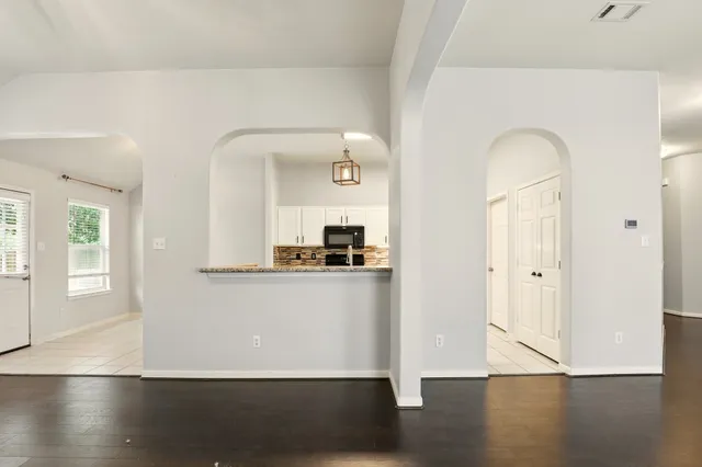 a view of a living room with wooden floor and a window