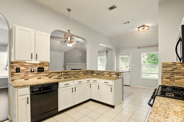 a kitchen with a stove a sink and a microwave