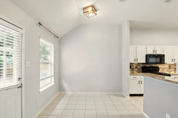 a kitchen with granite countertop a stove a sink and a microwave