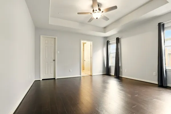 an empty room with wooden floor and window