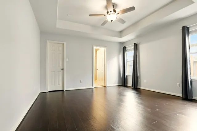 an empty room with wooden floor and window