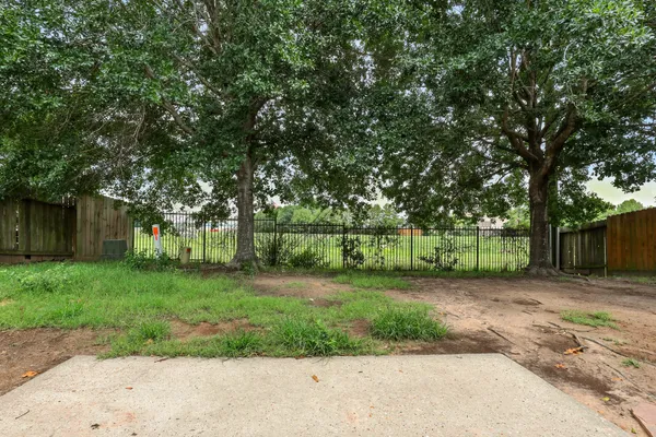 a view of a yard with wooden fence