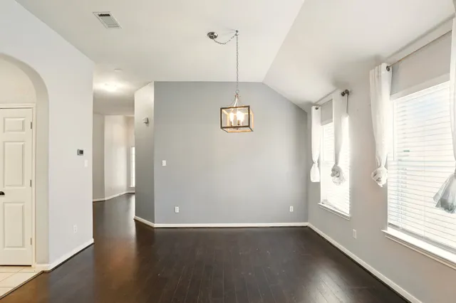 a view of a hallway with wooden floor and a window