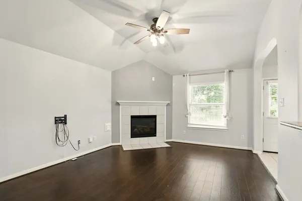 an empty room with windows and fireplace