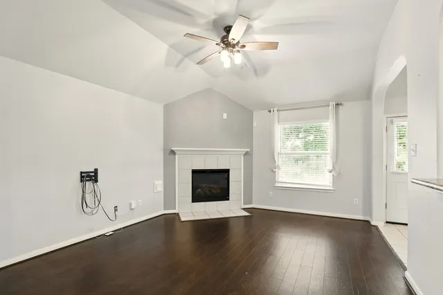 an empty room with windows and fireplace