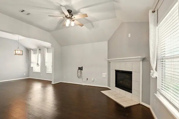 an empty room with windows and fireplace