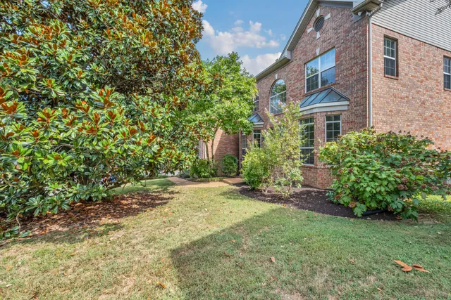 a view of an empty room with window and hardwood floor