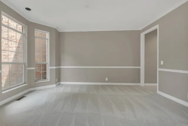 a view of an empty room with window and fireplace