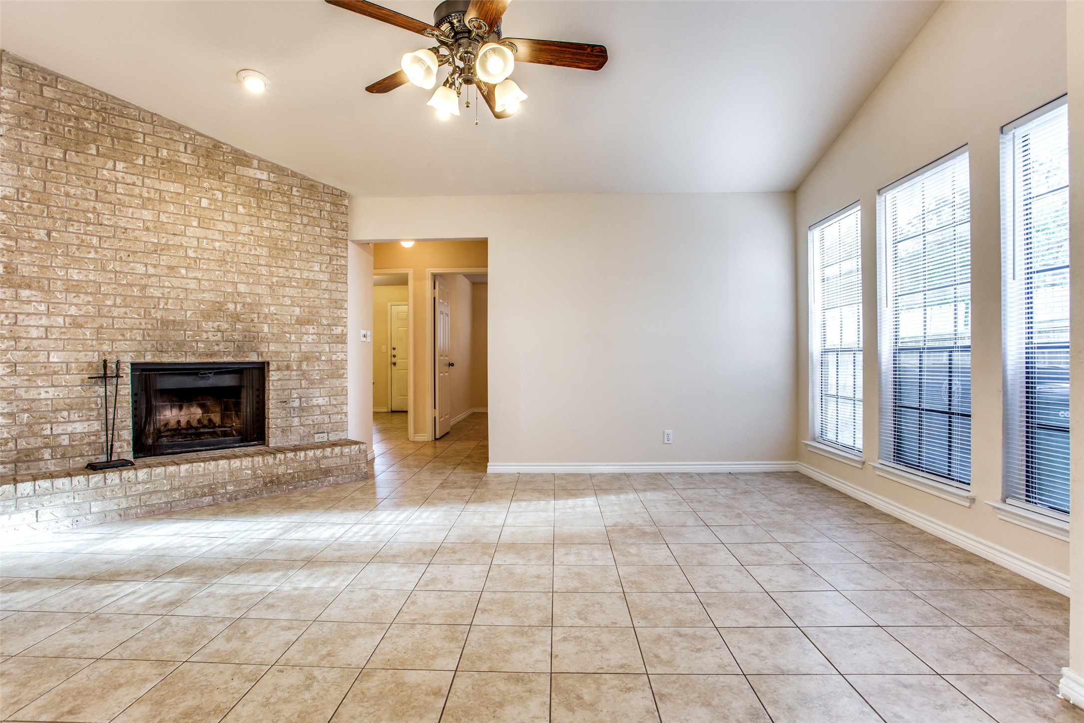 8811 Clearbrook Trail Austin, TX 78729 - Photo 16 of 38 rt B - A spacious living area offers a cozy fireplace and abundant natural light from multiple windows.