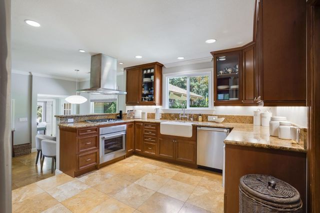 a kitchen with stainless steel appliances granite countertop a stove a sink and a refrigerator