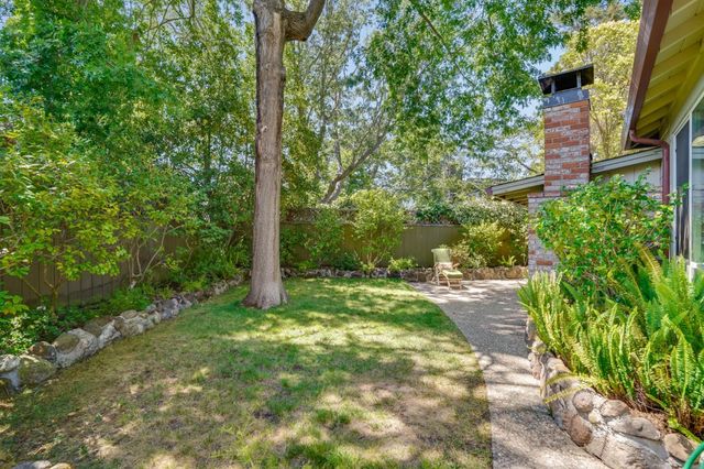 a view of a patio with table and chairs and floor to ceiling window