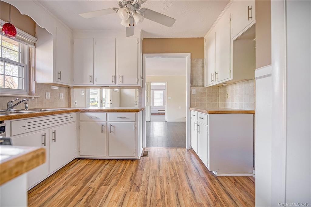 12001 Idlewild Road, Unit 7 Matthews, NC 28105 - Photo 2 of 29 a kitchen with granite countertop white cabinets and white appliances