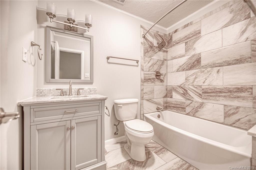 12001 Idlewild Road, Unit 7 Matthews, NC 28105 - Photo 26 of 29 a bathroom with a granite countertop toilet sink and mirror