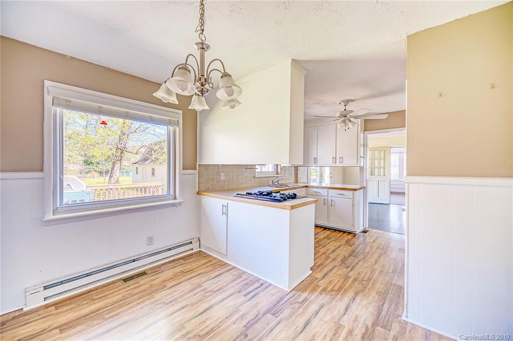 12001 Idlewild Road, Unit 7 Matthews, NC 28105 - Photo 5 of 29 a kitchen with kitchen island wooden floors and a stove