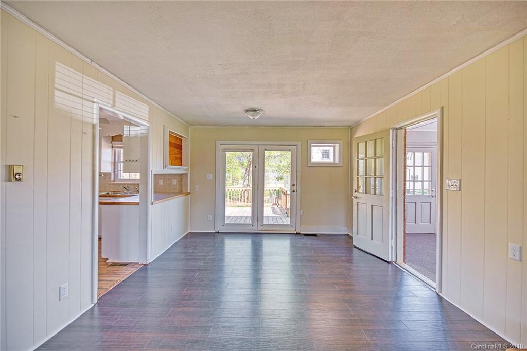 12001 Idlewild Road, Unit 7 Matthews, NC 28105 - Photo 7 of 29 a view of an empty room with a window and wooden floor