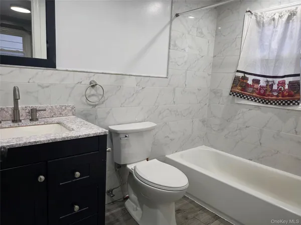 a bathroom with a sink vanity mirror and toilet