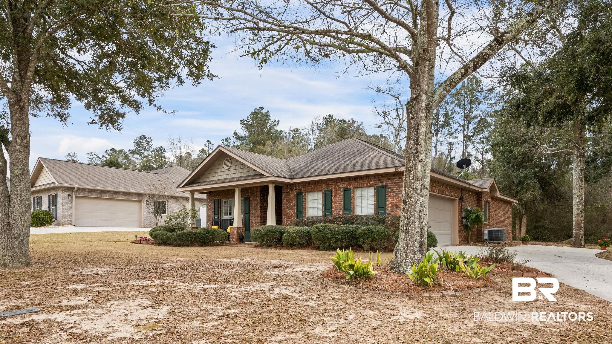 1090 Melbourne Court Foley, AL 36535 - Photo 33 of 38 View of front facade featuring an attached garage, brick siding, covered porch, driveway, and roof with shingles