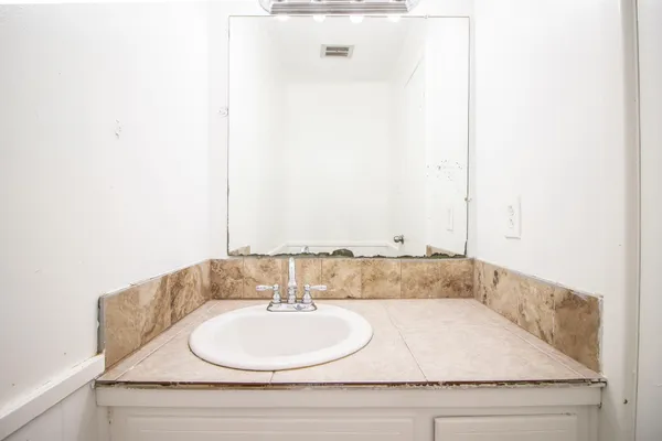 a bathroom with a granite countertop sink and a mirror