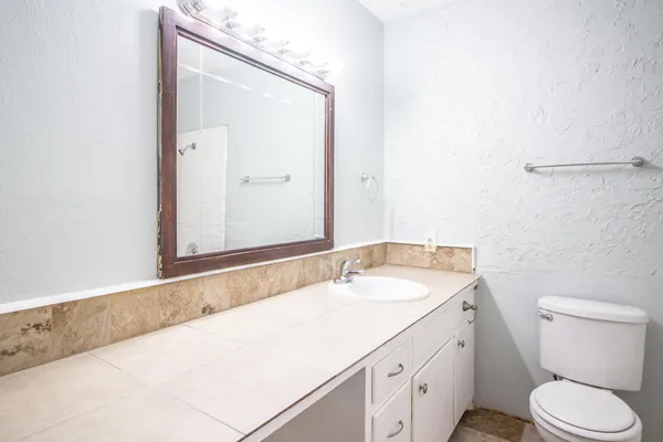 a bathroom with a granite countertop sink and a mirror