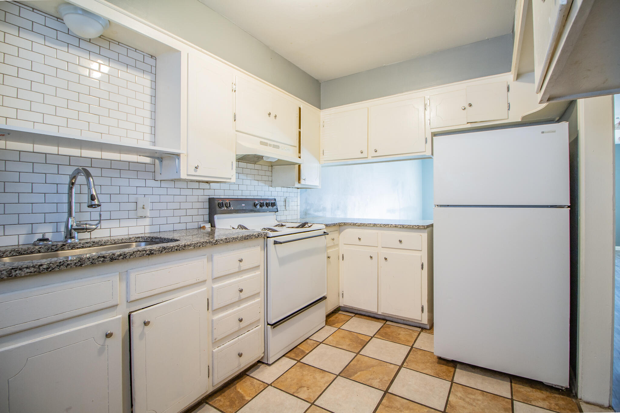 2101 49th Street Lubbock, TX 79412 - Photo 23 of 31 a kitchen with white cabinets sink and a refrigerator