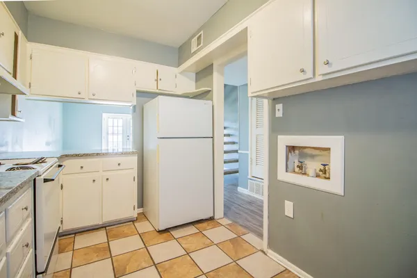 a kitchen with cabinets and a refrigerator