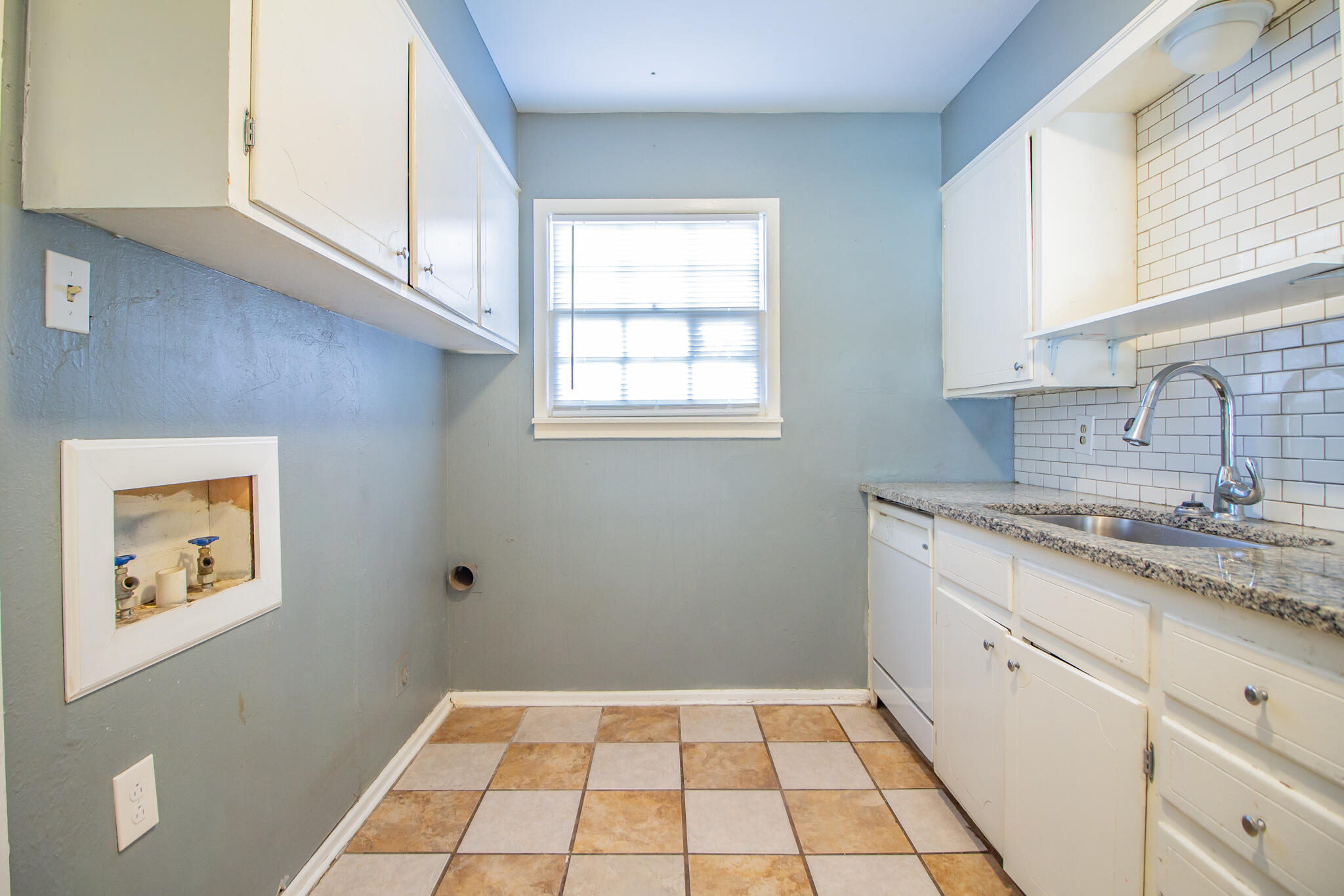 2101 49th Street Lubbock, TX 79412 - Photo 25 of 31 a kitchen with a sink a stove cabinets and a window